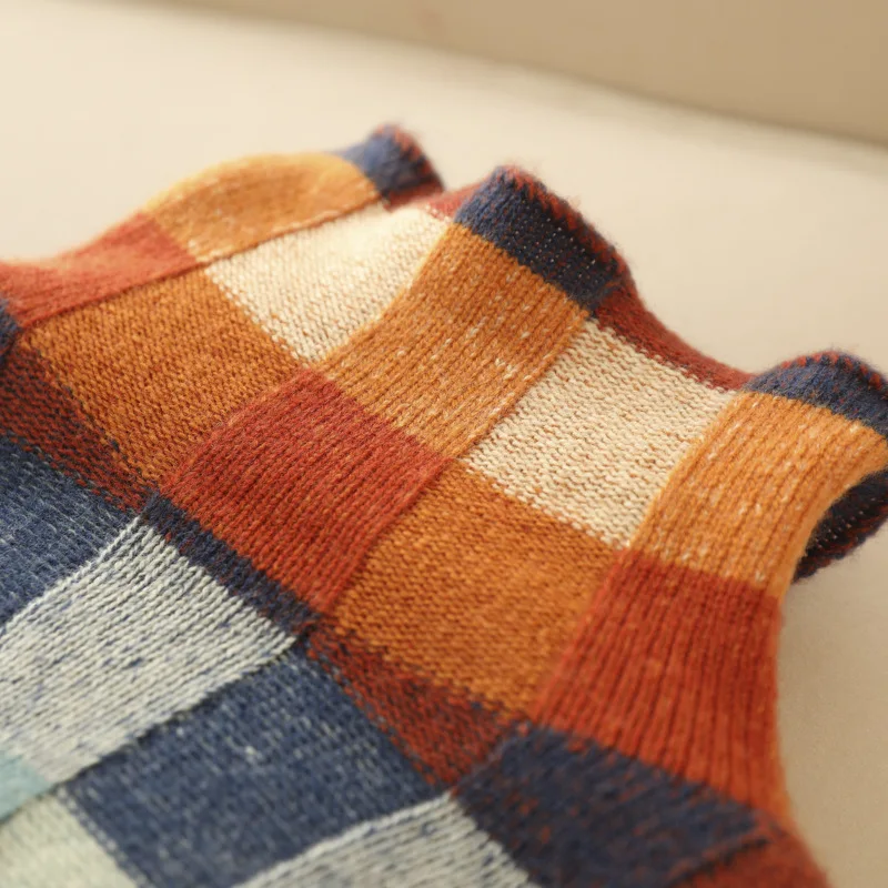 Multicolor plaid knit panel detail with orange, teal, blue, and cream stripes
