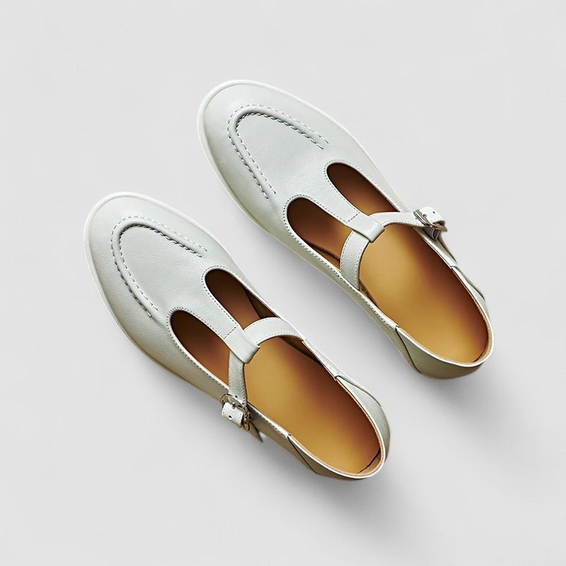 Pair of beige Mary Jane shoes with low heel, front straps and buckles