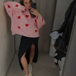 Light pink soft pullover sweater with red heart pattern, long sleeves and crew neck.