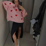 Light pink soft pullover sweater with red heart pattern, long sleeves and crew neck.