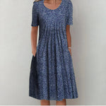 Navy polka-dot midi dress with scoop neckline and short sleeves, gathered skirt