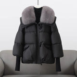 Black puffer jacket with gray faux fur collar, button-front zip and flap pockets