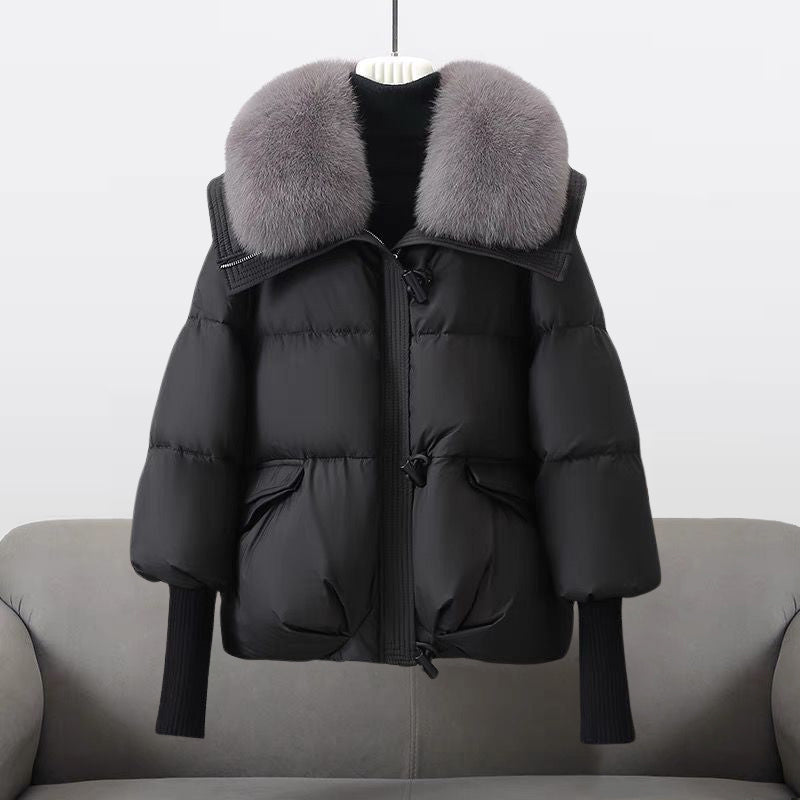 Black puffer jacket with gray faux fur collar, button-front zip and flap pockets