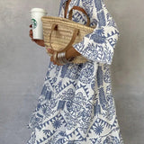 Blue-and-white patterned V-neck mini dress with long sleeves and tiered flared skirt.