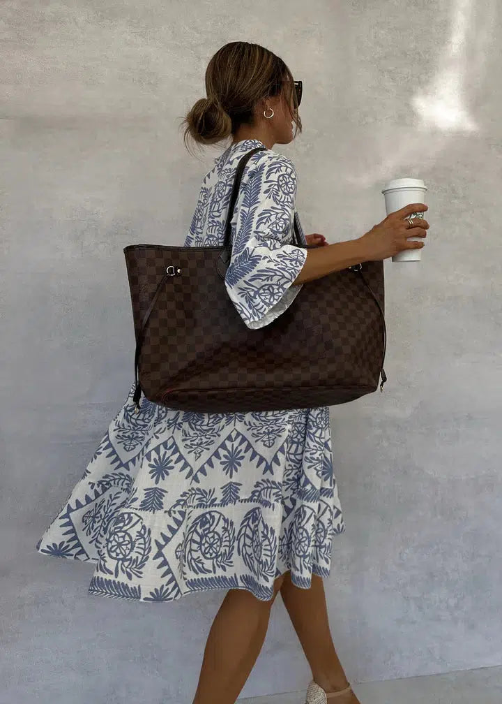 Back view of blue-and-white patterned V-neck mini dress with long sleeves.