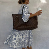 Back view of blue-and-white patterned V-neck mini dress with long sleeves.