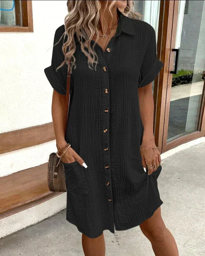 Black polo shirt dress with short sleeves, button placket, and side pockets
