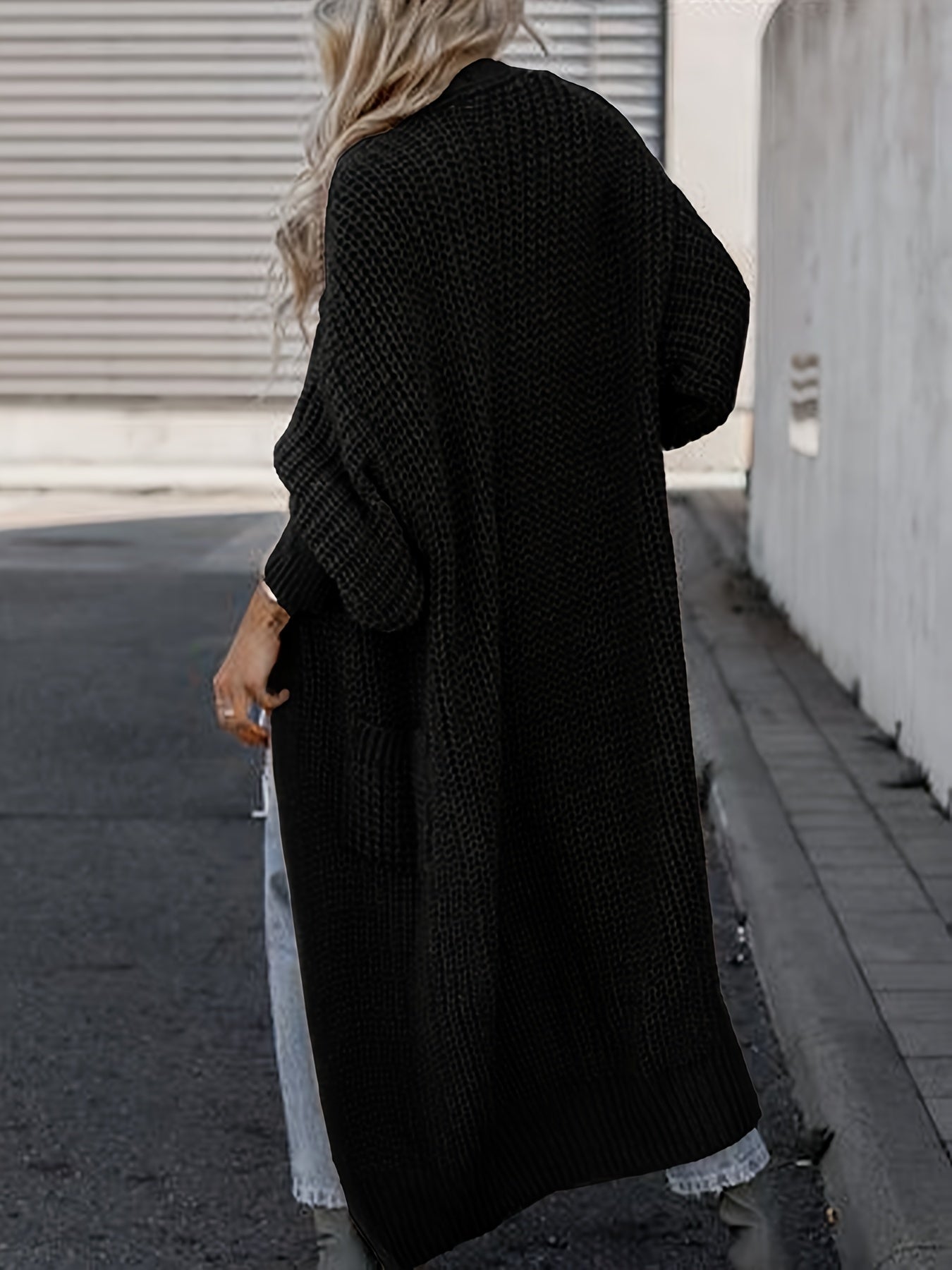 Black long knit cardigan with open front, long sleeves, and side pockets