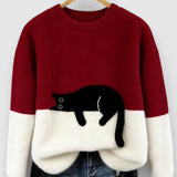 Red and white two-tone sweatshirt with black cat graphic on the front