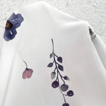 White fabric close-up with blue and mauve floral print