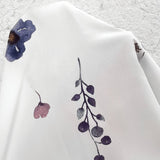 White fabric close-up with blue and mauve floral print