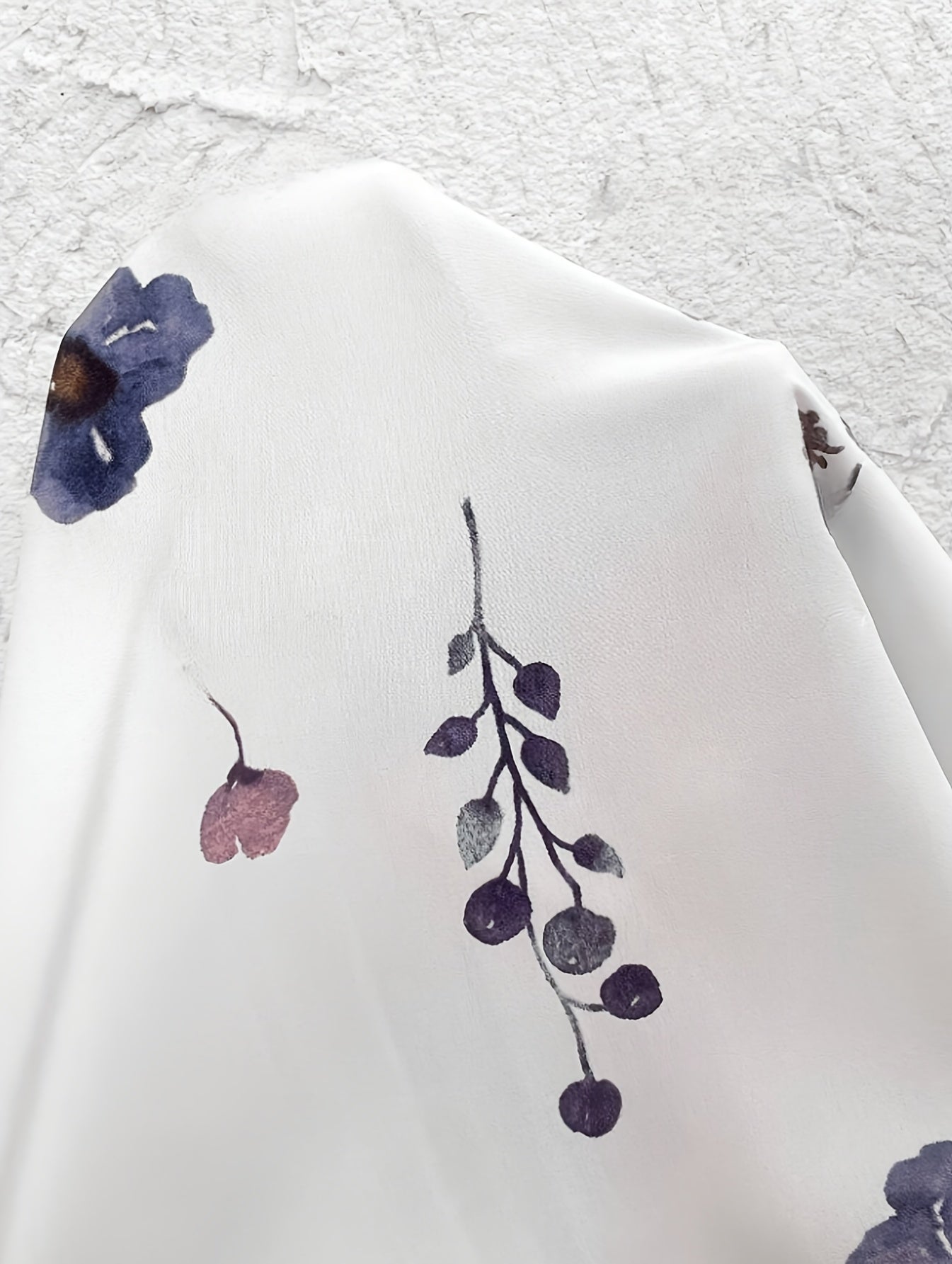 White fabric close-up with blue and mauve floral print