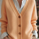 Light orange knit V-neck cardigan with button front and ribbed cuffs, long sleeves