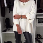 White long-sleeve knit pullover with round neckline and buttoned cuffs