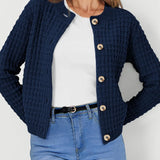 Navy knit cardigan with button front and long sleeves, textured waffle pattern