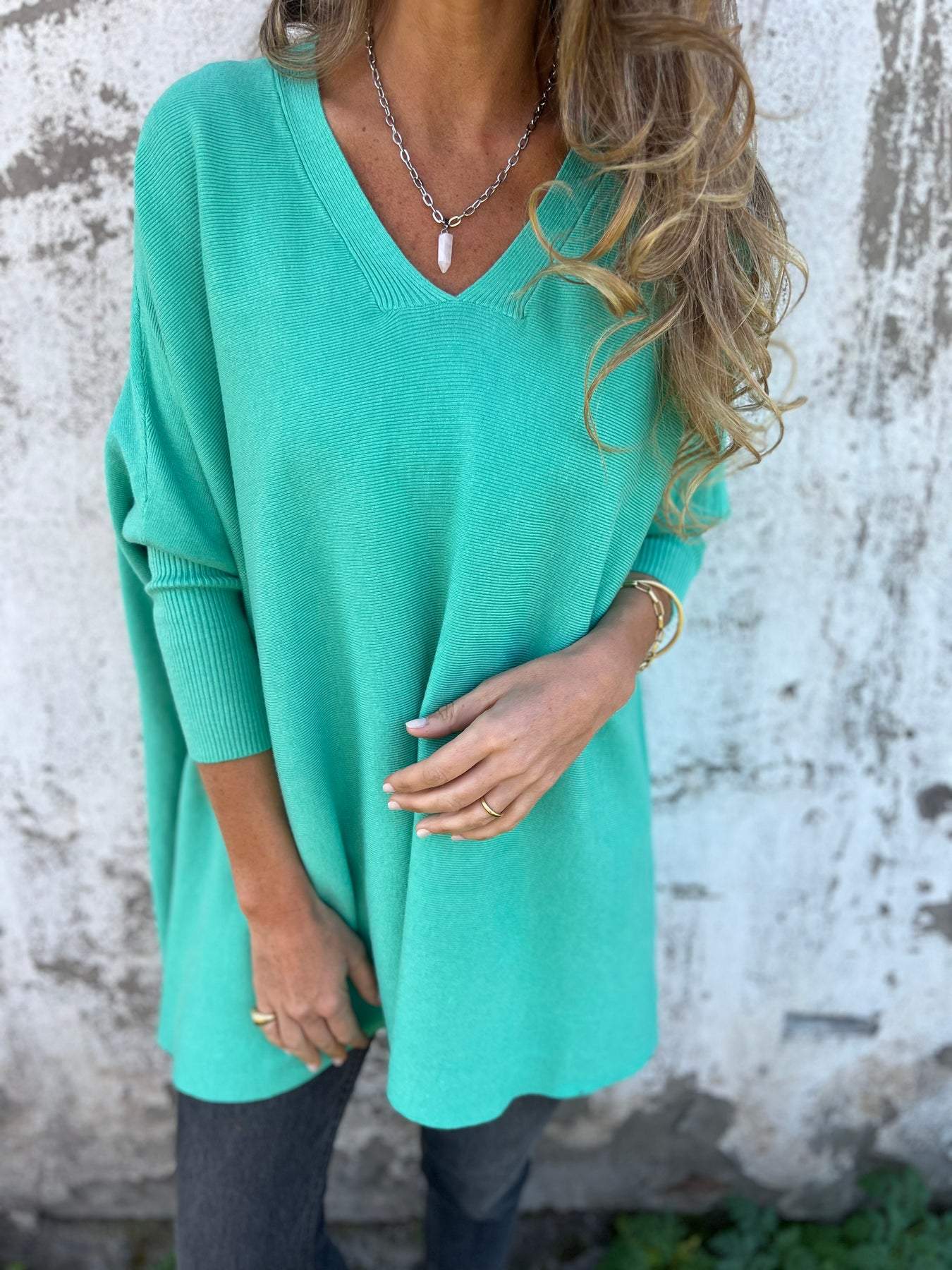 Teal V-neck pullover sweater with three-quarter sleeves and relaxed fit.