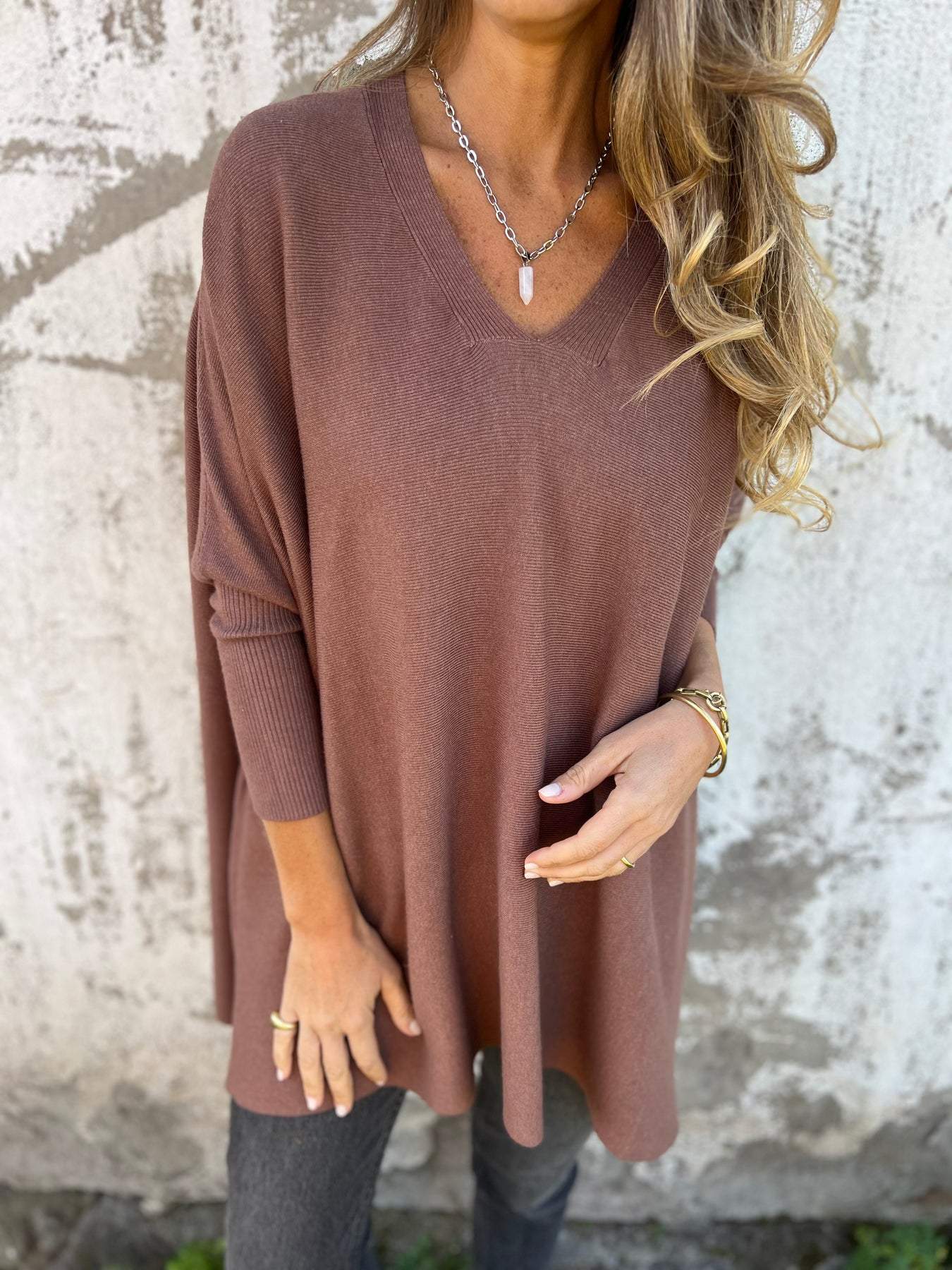 Brown V-neck pullover sweater, three-quarter sleeves and loose drape.