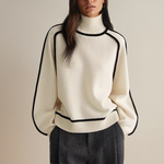White knit pullover with high ribbed turtleneck and black contrast trim
