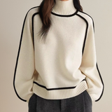 Off-white sweater with black trim, ribbed turtleneck and long sleeves