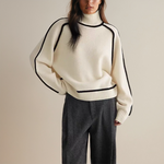 White knit pullover with high ribbed mock neck and black contrast piping