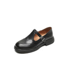 Black Mary Jane shoe with buckle strap, wingtip detailing, and chunky sole