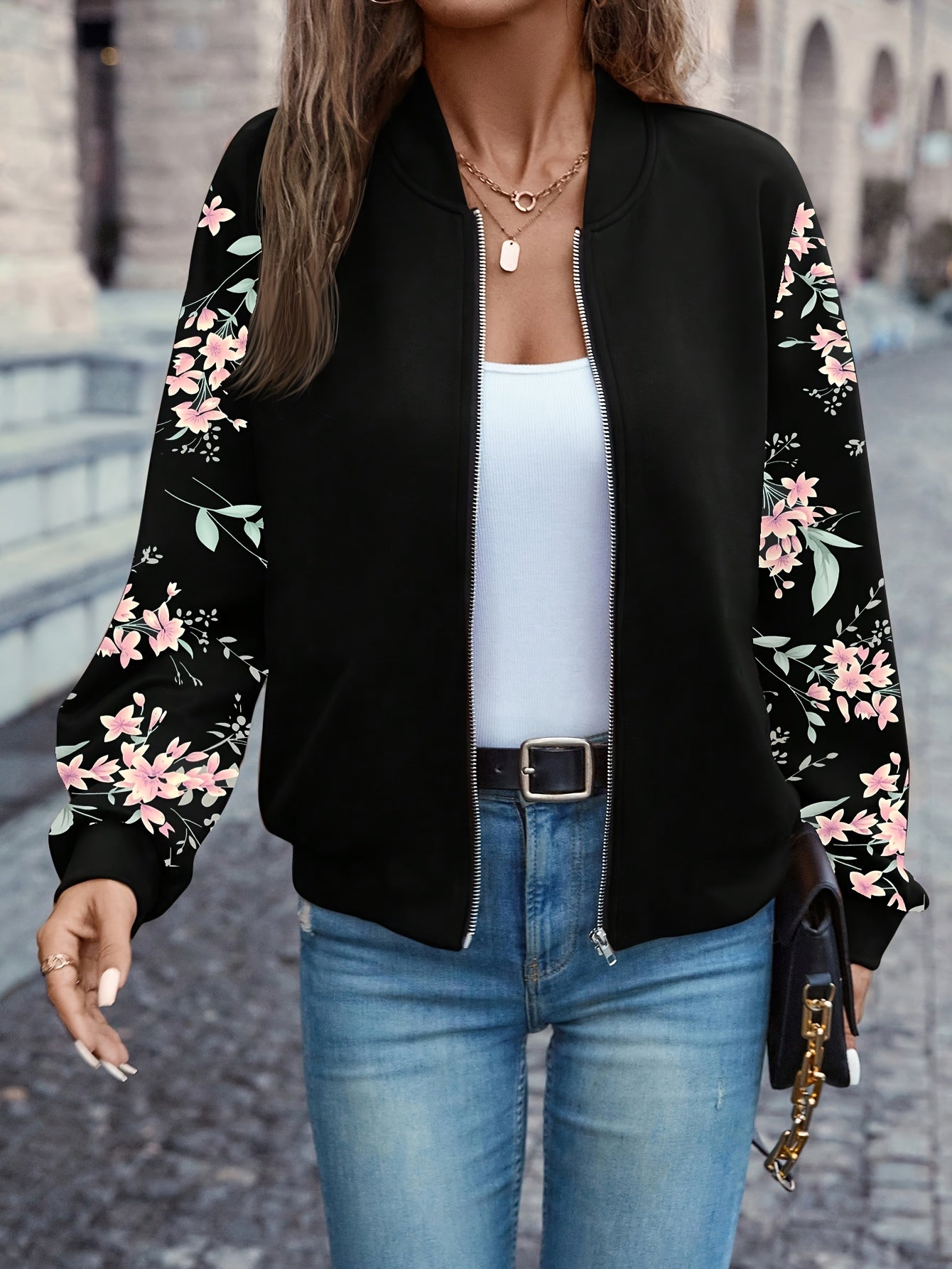 Black zip-up jacket with floral print sleeves, ribbed hem and cuffs