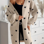 Heart-pattern knit cardigan, open front and long sleeves, light beige with dark heart print.