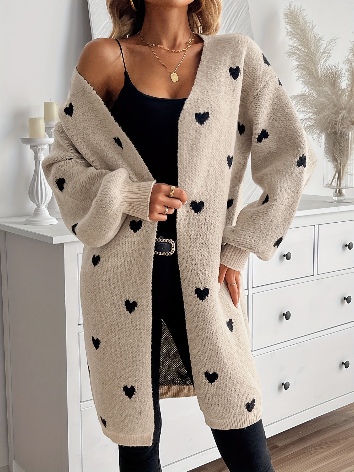 Heart-pattern knit cardigan, open front and long sleeves, light beige with dark heart print.