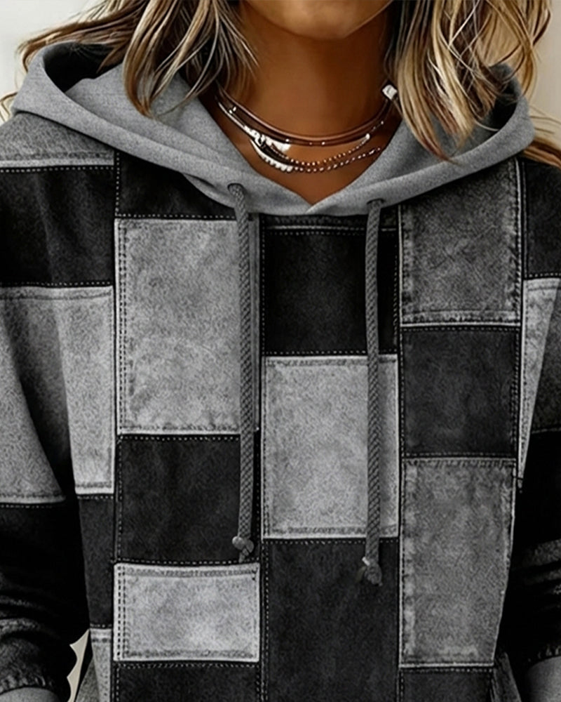 Gray and black patchwork hoodie close-up, hood with drawstring and stitched squares