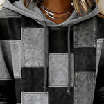 Gray and black patchwork hoodie close-up, hood with drawstring and stitched squares