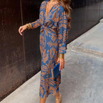Blue patterned midi dress with V-neck, long sleeves, and tied waist