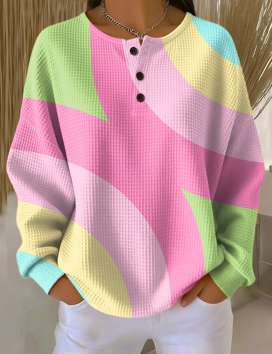 Abstract geometric pullover sweater with buttoned henley neckline; pink, green, yellow, blue.