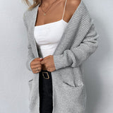 Long gray knit cardigan with open front and two patch pockets, long sleeves