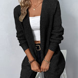 Black long knit cardigan with open front, ribbed cuffs, and two patch pockets