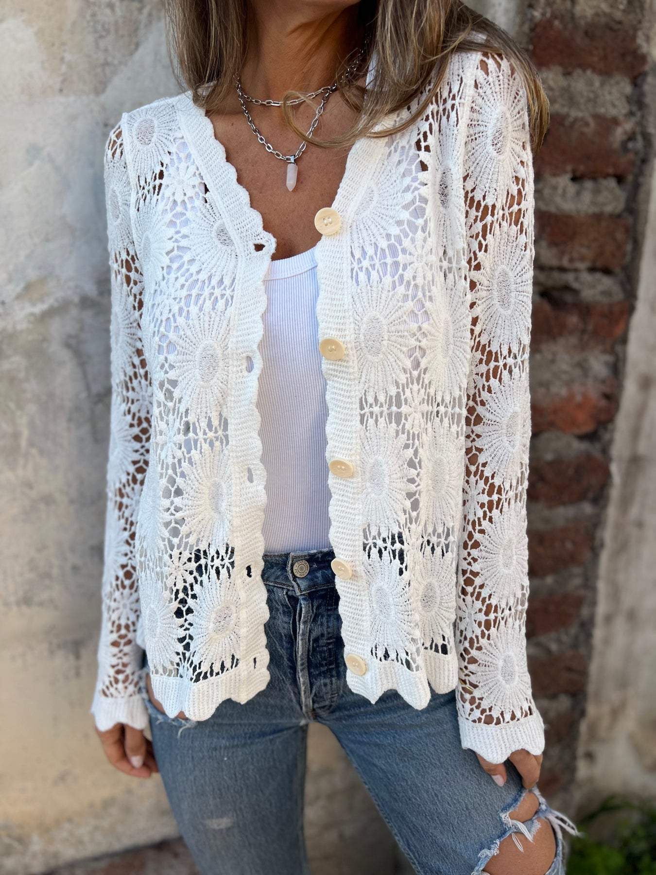 White lace cardigan with V-neck, gold buttons, long sleeves, open floral pattern