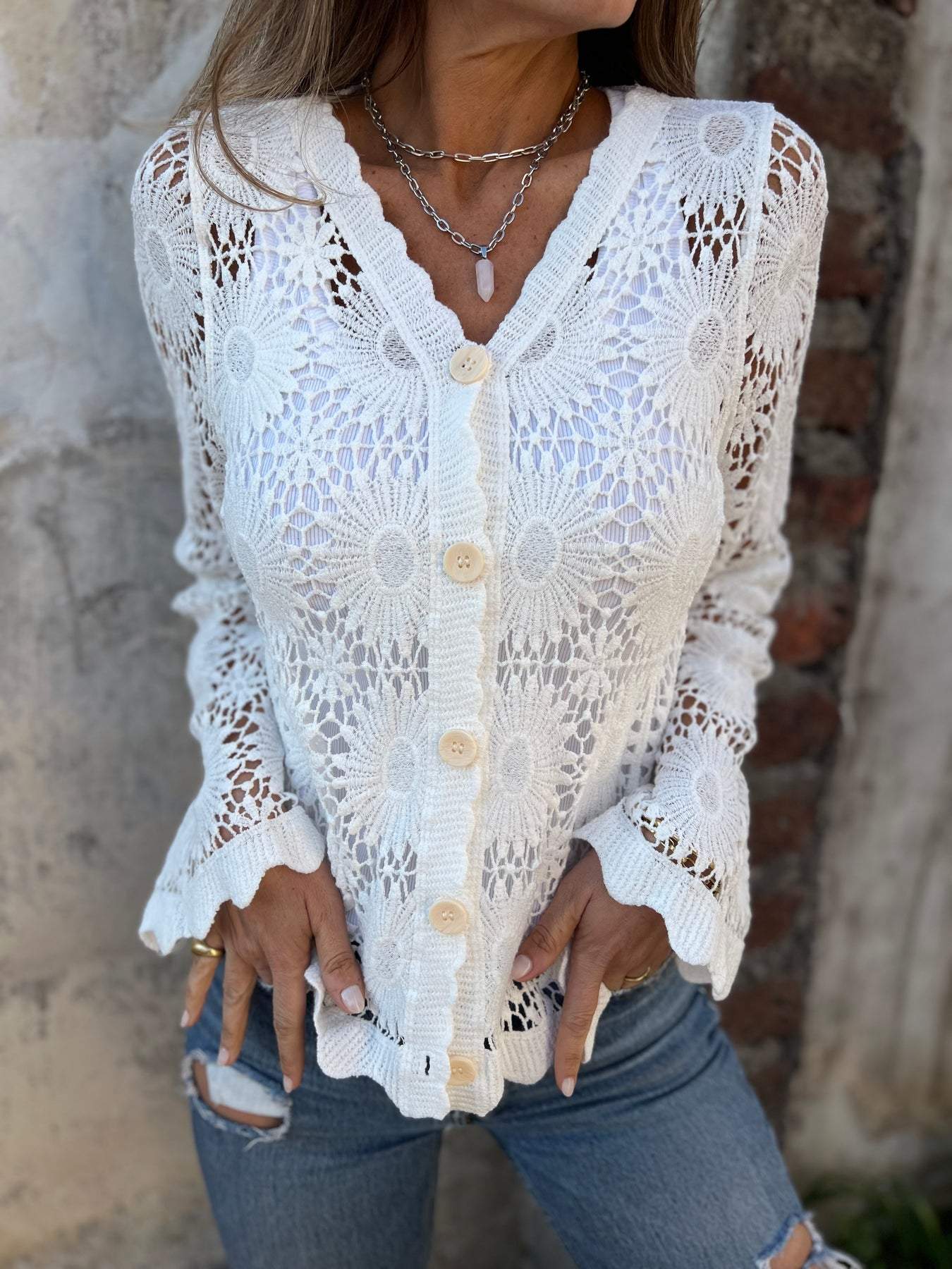 White lace cardigan with V-neck, button front, and long sleeves; scalloped openwork