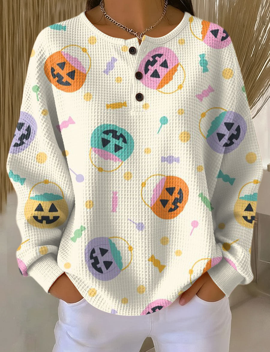 White knit pullover sweater with button front and colorful Halloween pumpkin graphics
