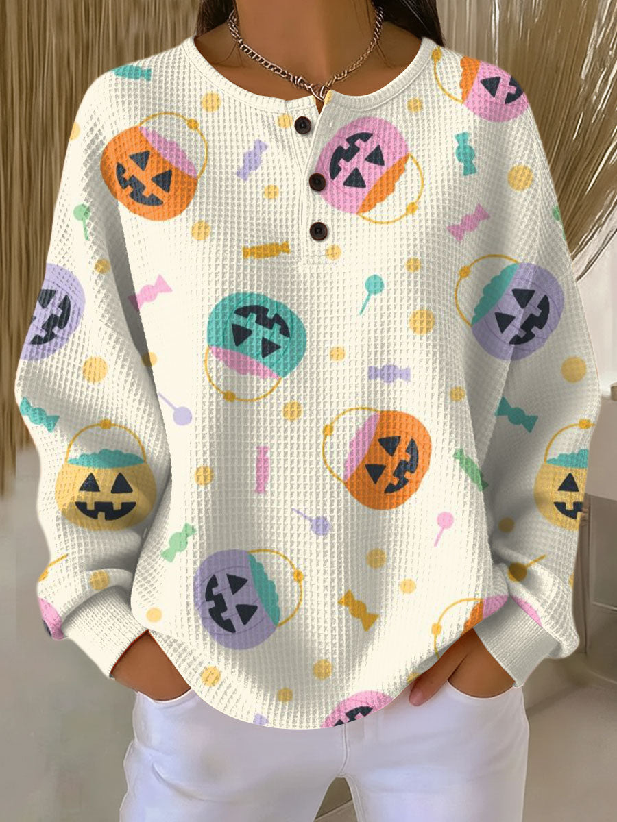 White knit pullover sweater with button front and colorful Halloween pumpkin graphics