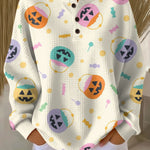 White knit pullover sweater with button front and colorful Halloween pumpkin graphics