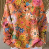 Orange floral print pullover sweater with long sleeves and henley button placket