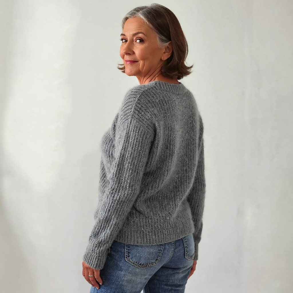 Gray knit crewneck sweater with long sleeves; side view of ribbed cuffs and hem