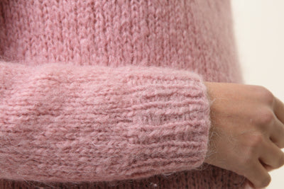 Light pink fuzzy knit sweater sleeve cuff with ribbed texture