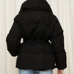 Black padded hooded jacket with tie belt, shown from the back, long sleeves.