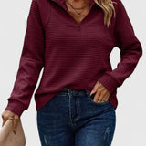 Burgundy ribbed half-zip knit sweater with long sleeves.
