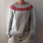 Gray knit pullover sweater with red patterned yoke at crew neckline