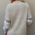 Back of cream knit sweater with textured stitch, crew neck, long sleeves, ribbed cuffs