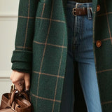 Dark green plaid coat with cuffed sleeve and front buttons, worn over blue jeans