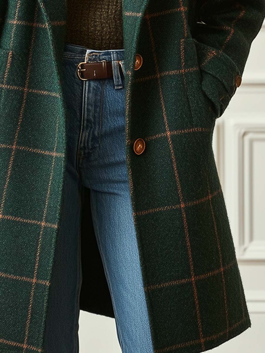 Dark green plaid coat with two front buttons and long hem, worn over blue jeans