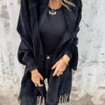 Black long-sleeve wrap cardigan with fringe hem, open front drape and collar