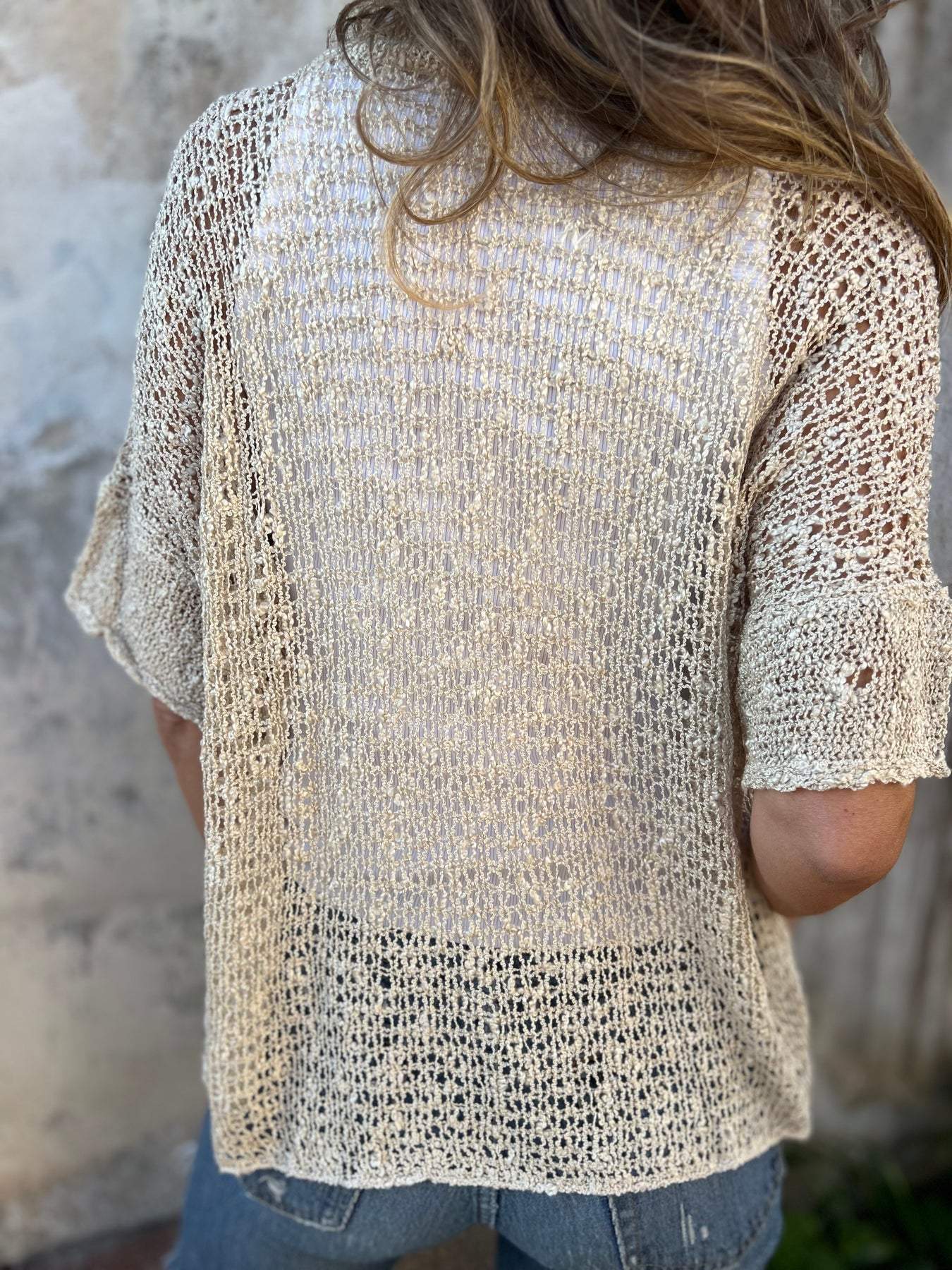 Light beige textured short-sleeve blouse with V-neck and woven pattern